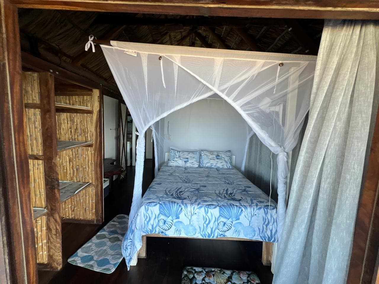 Double bedroom with a draped mosquito net and coastal linen